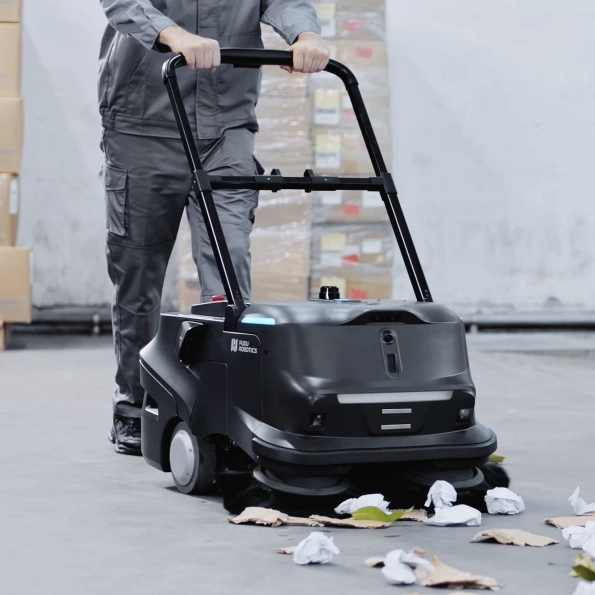 Pudu MT1 Kehrroboter im manuellen Betrieb mit Schiebebügel beim Aufsammeln von Blättern und Papier