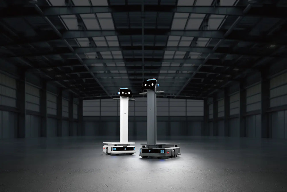 Zwei autonome T300 Roboter in Weiß und Schwarz stehen nebeneinander in einer großen Industriehalle
