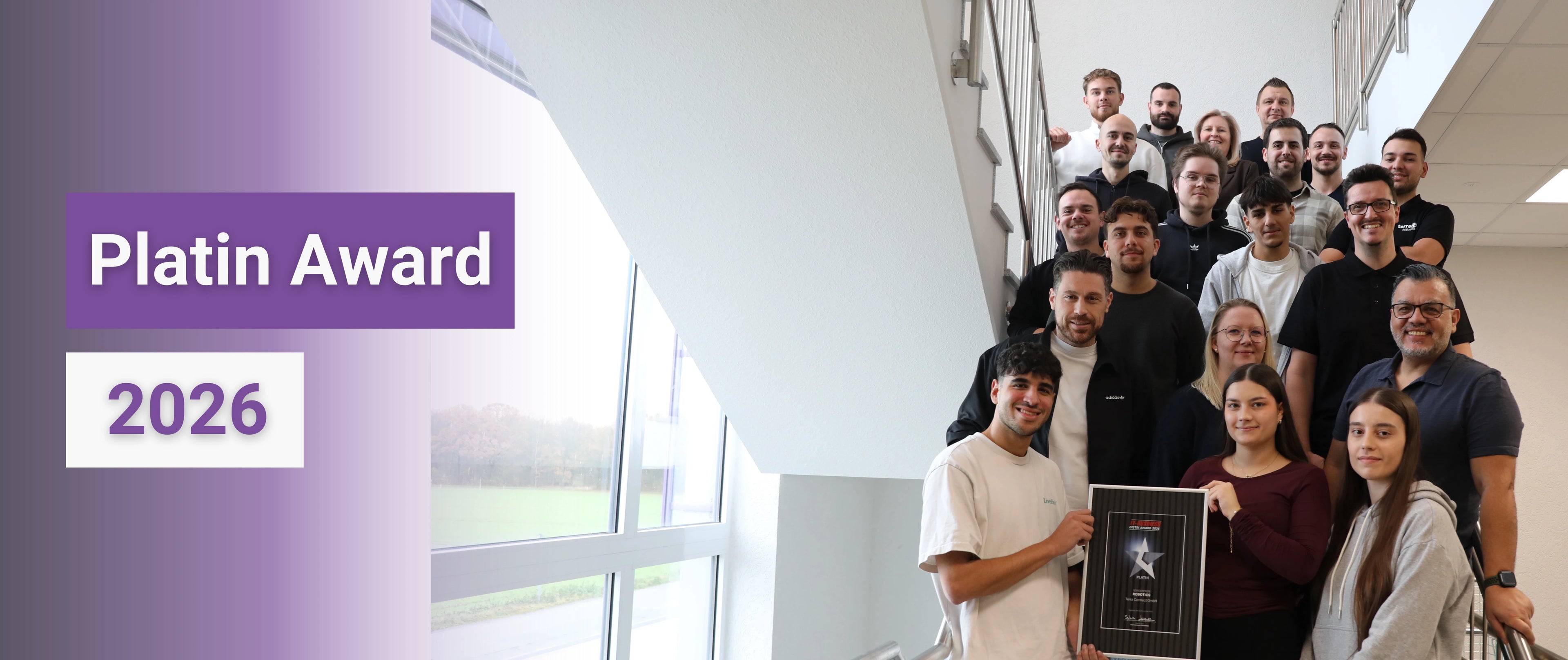 Terra Robotics Team mit Platin Award 2026 auf Treppe im Firmengebäude für herausragende Service und Reinigungsroboter