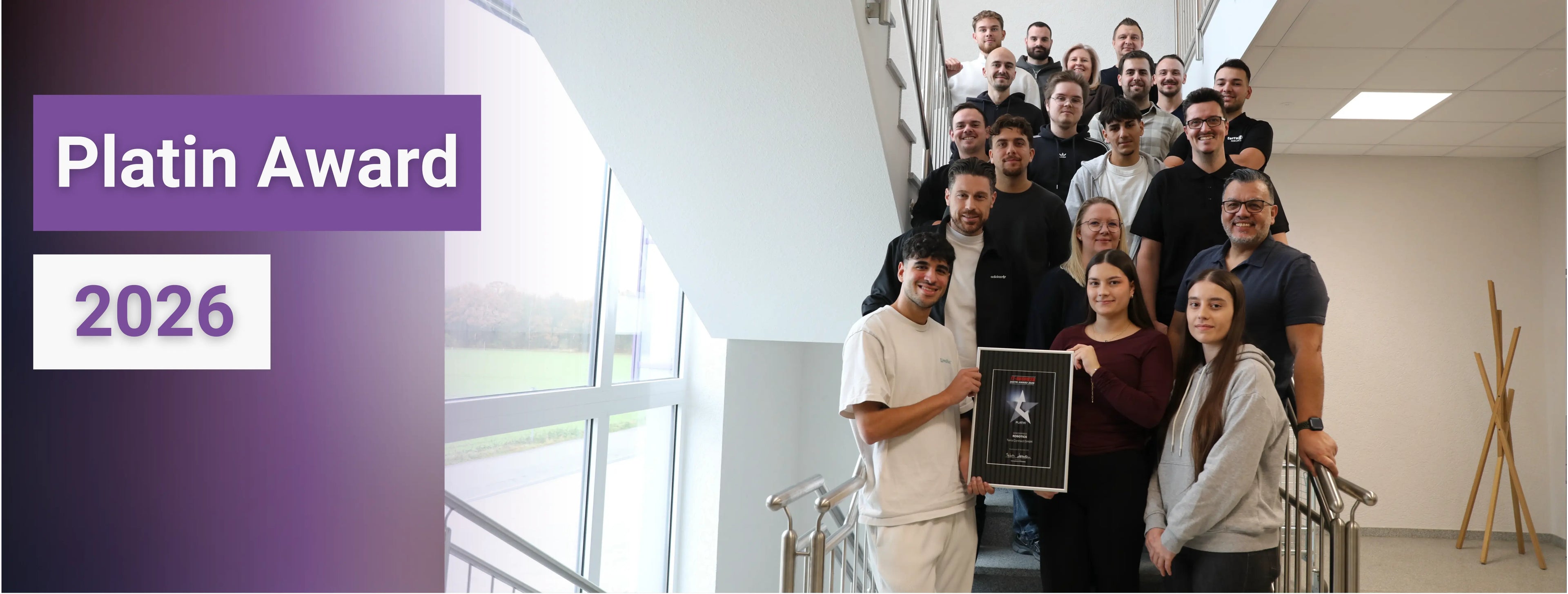 Terra Robotics Team mit Platin Award 2026 auf Treppe im Firmengebäude für herausragende Service und Reinigungsroboter