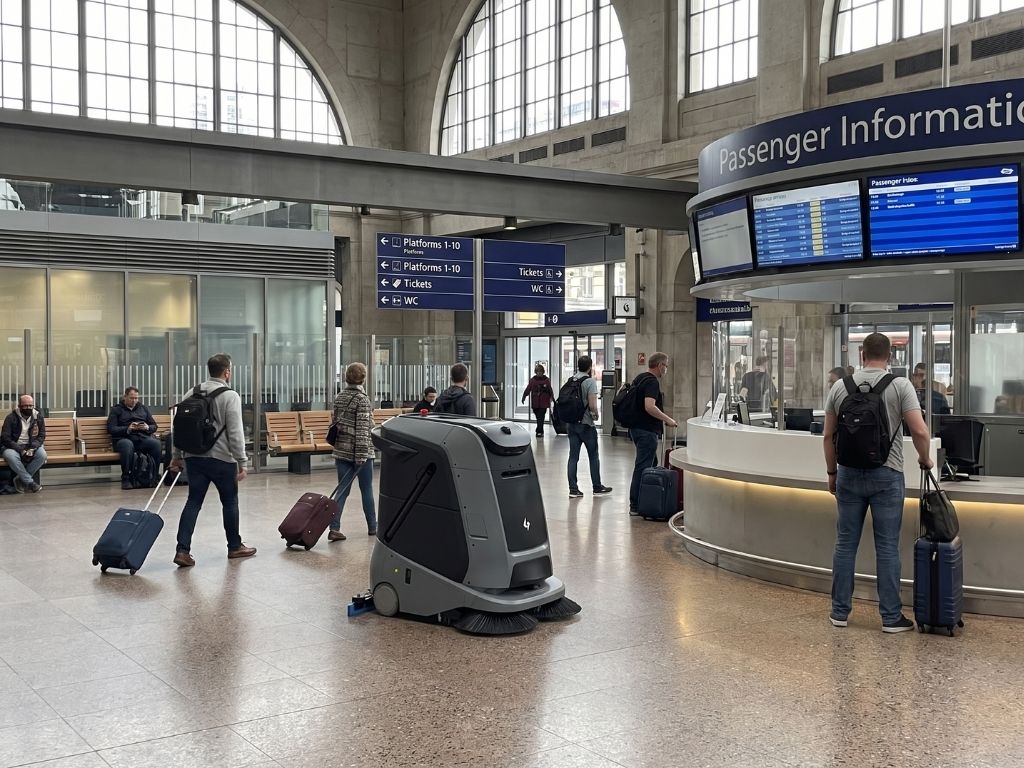 Gausium Marvel Reinigungsroboter bei der autonomen Bodenreinigung im stark frequentierten Bahnhofsbereich