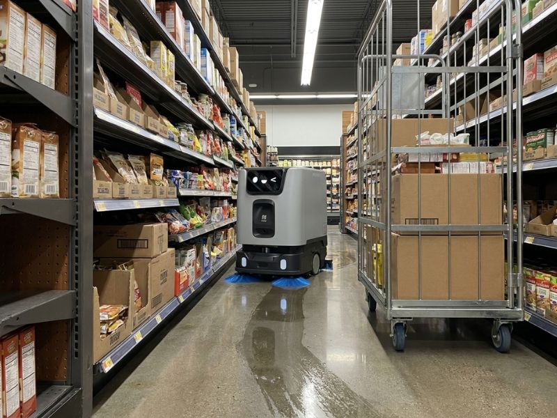 PUDU ET1 Reinigungsroboter bei der autonomen Bodenreinigung in einem schmalen Supermarktgang